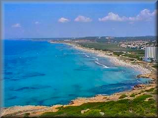 La extensa playa de Son Bou vista desde el Mirador de Son Bou, un cordon rocoso que la separa de Cala Llucalari